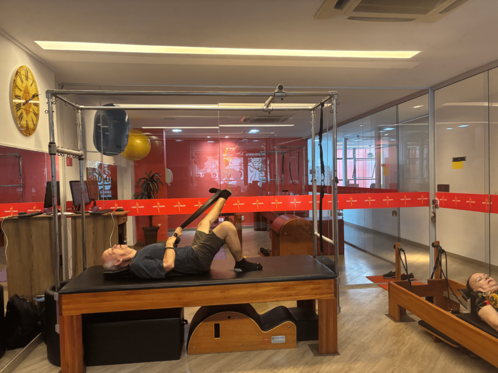 Clinica ação e saúde - homem fazendo pilates com instrutor